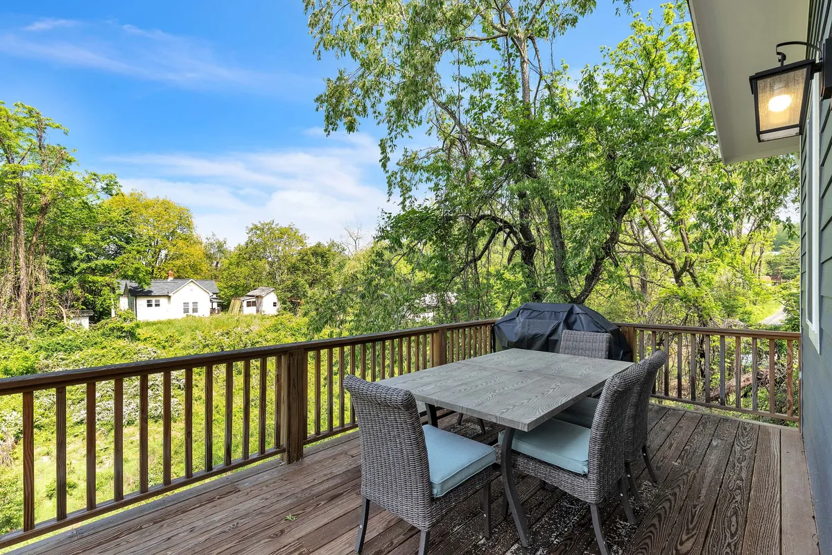 An outdoor dining area set against lush greenery, with houses in the background. The table is ready for family meals or celebrations, and the surrounding nature adds tranquility and privacy—ideal for families enjoying outdoor living.